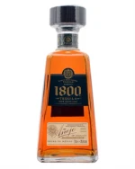 Mørk ravfarvet flaske 1800 Añejo Tequila med signatur på etiketten