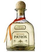 Flaske Patrón Reposado Tequila med gyldent bagfarvet glas og sort etiket